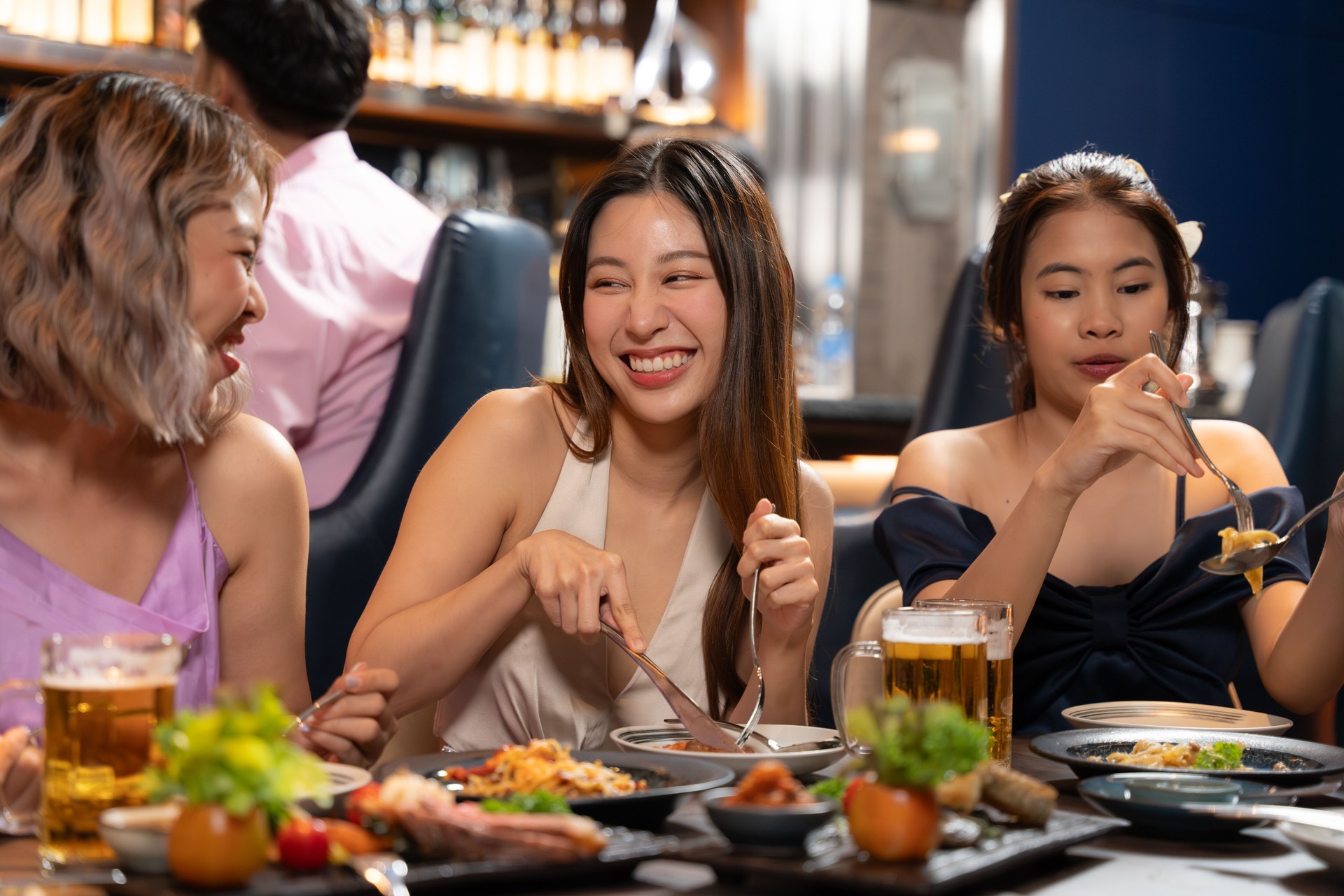 Beautiful Asian woman is Relishing a Delightful Dinner with Friends.